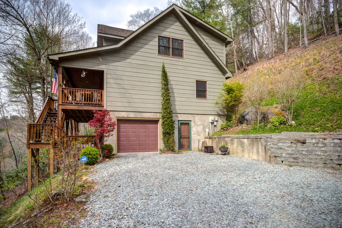 This image features the house facade, a gravel driveway, and a landscaped area, welcoming guests as they arrive. The porch and open areas hint at group-friendly outdoor spaces, ideal for family reunions or friends meeting before heading out to enjoy local attractions.